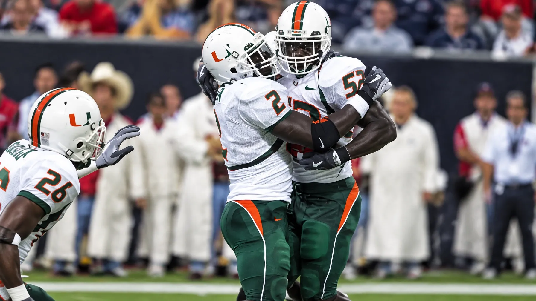 Two Miami Hurricanes players in white jerseys wearing numbers 52 and 53