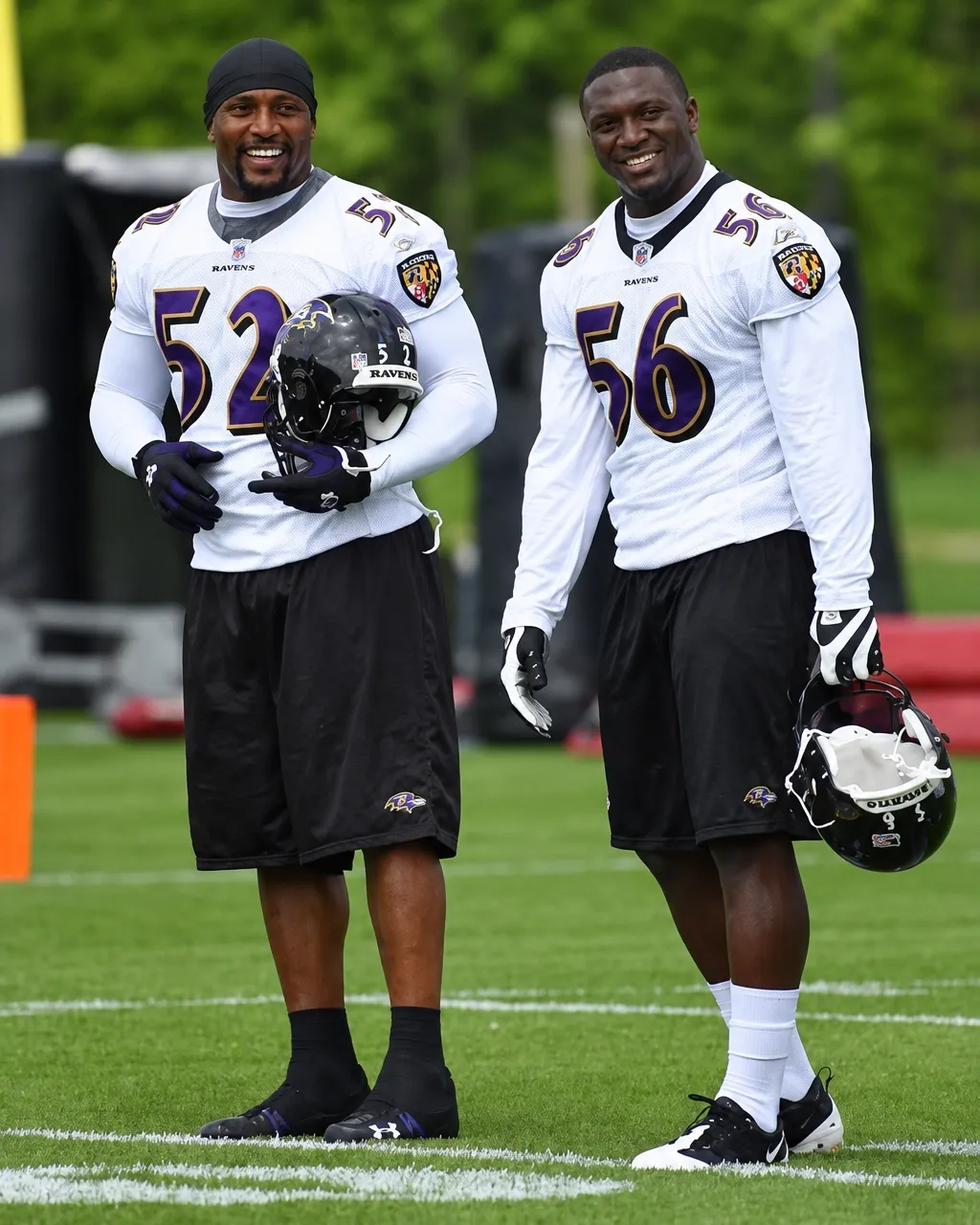 Two Baltimore Ravens players in white jerseys wearing numbers 52 and 56